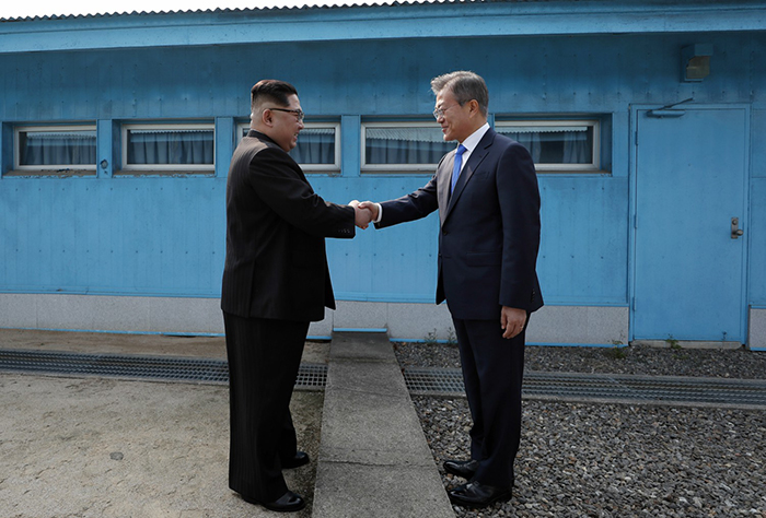  
North Korean leader Kim Jong Un (left) and President Moon Jae-in (right) on April 27 shake hands at the line of demarcation that divides both Koreas. (Pyeongyang Press Corps) 
